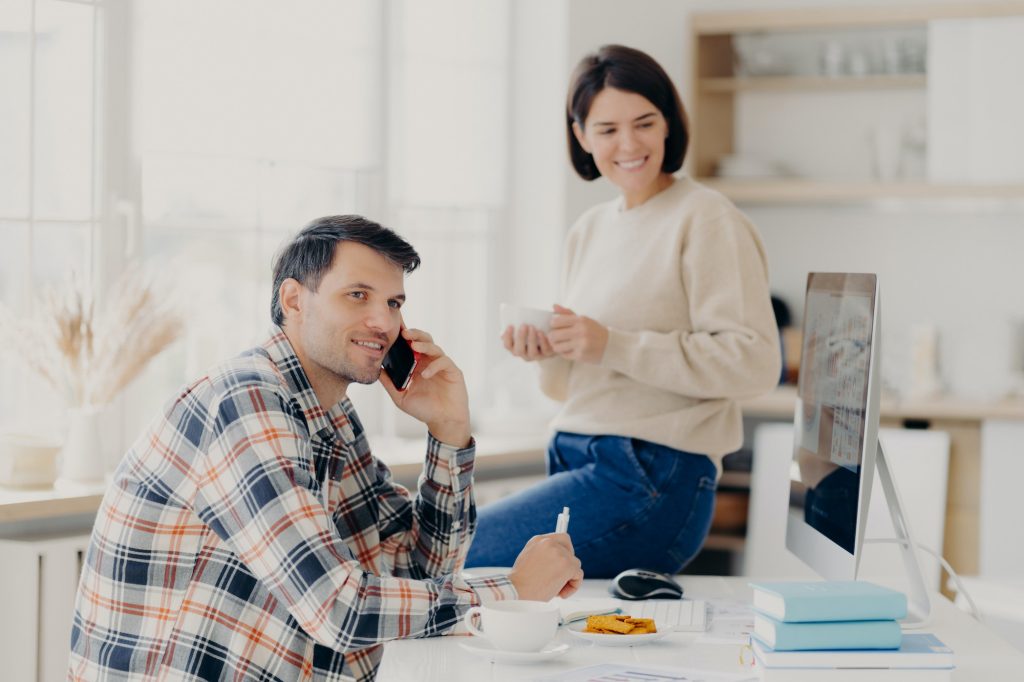 Pleased husband and wife manage finances at home, review bank accounts