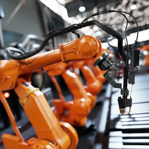 Robotic arms along assembly line in modern factory.